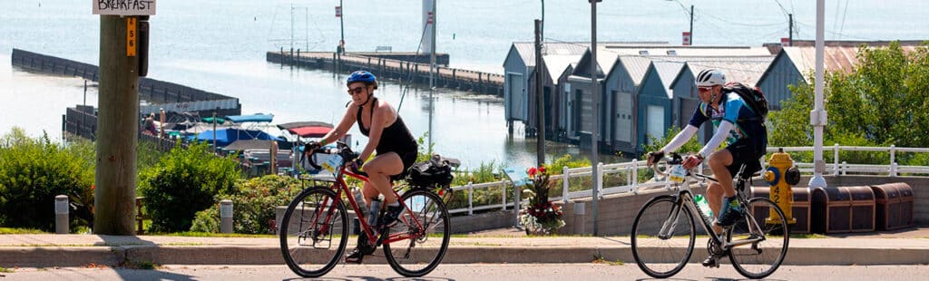 Participants of the 2025 Great Waterfront Trail Adventure cycling in front of a marina.