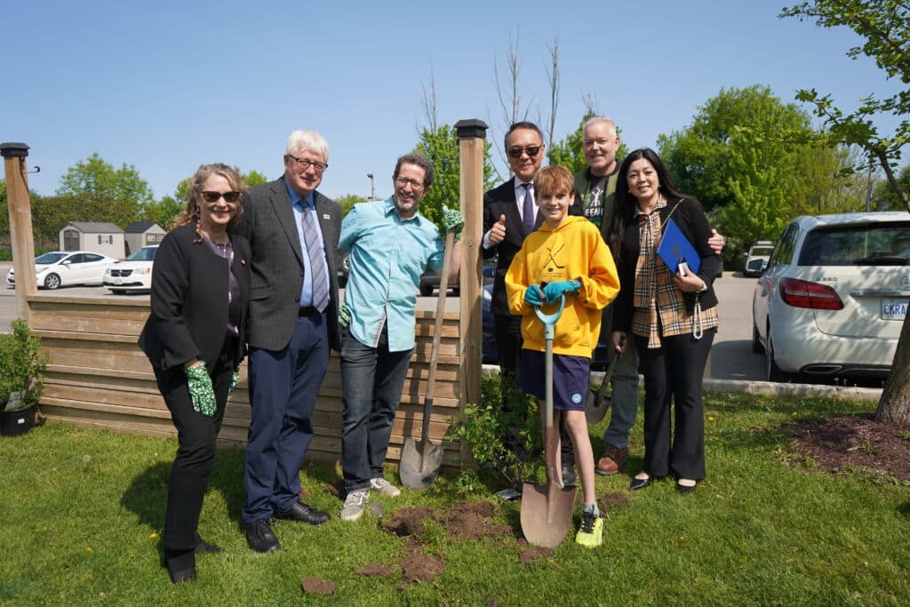 Group planting a tree outdoors.